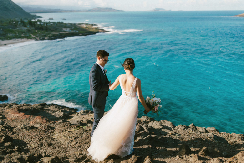 A couple standing on a cliff at their Hawaii Elopement, how to elope in Hawaii, Oahu Elopement Photographer and Videographer