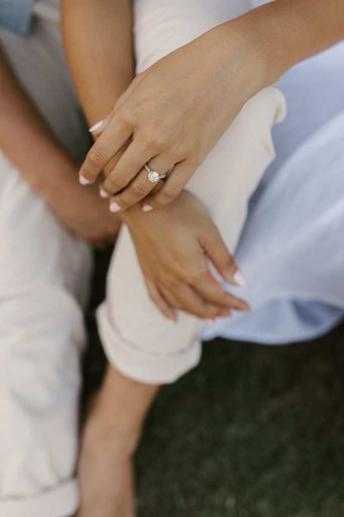 A close up of the fiancée's engagement ring as they sit together during their engagement session.