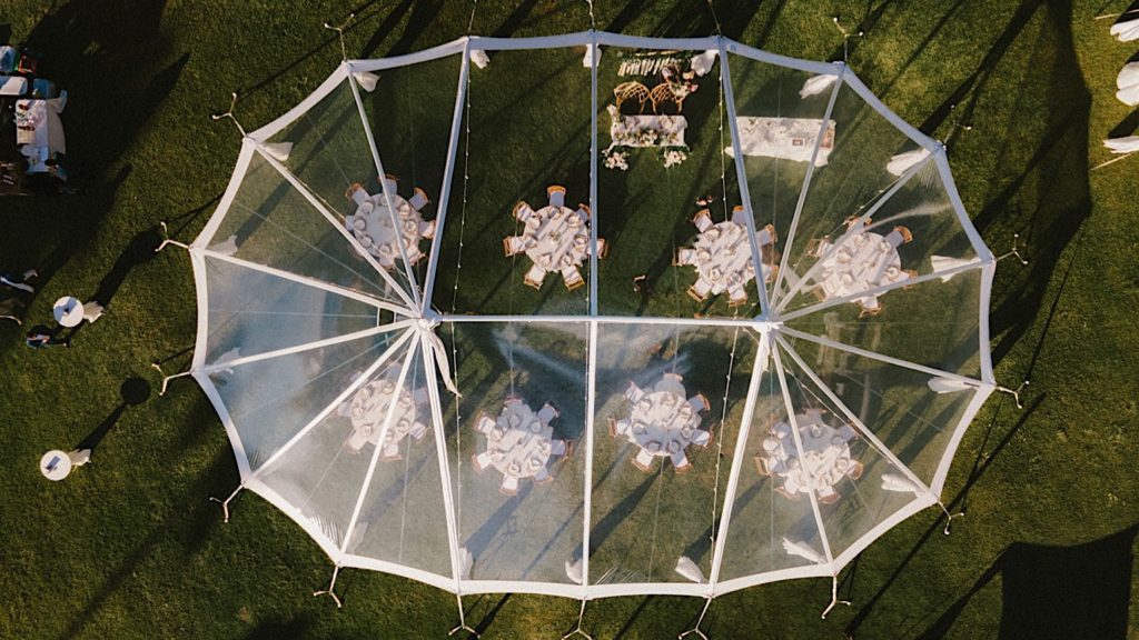 A top view of a wedding reception under a clear tent at the wedding venue Loulu Palm in Hawaii.
