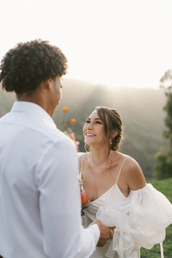 A bride smiles at her groom during their elopement ceremony.