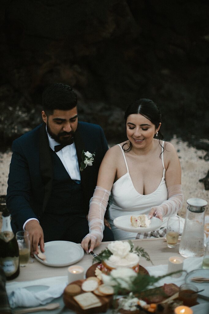 Photo of a bride and groom having a picnic together on Makapuu Beach