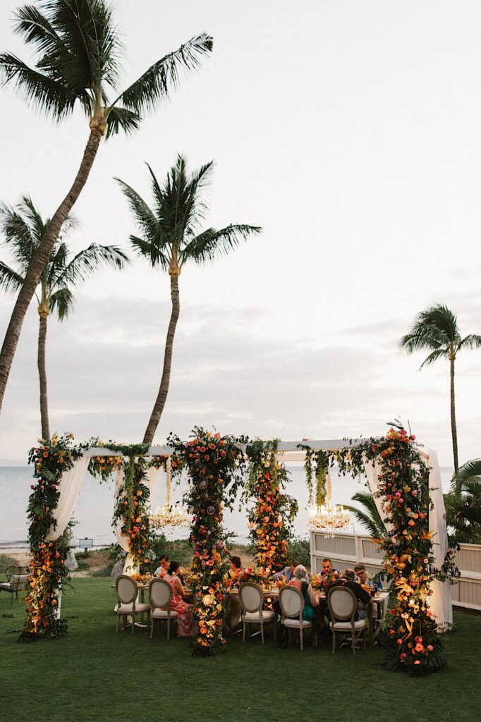 An outdoor wedding reception on Maui with the ocean in the background.