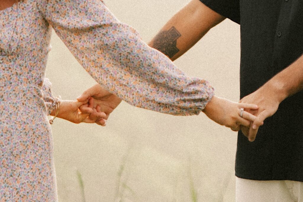 Close up photo of a couple holding hands during their family session