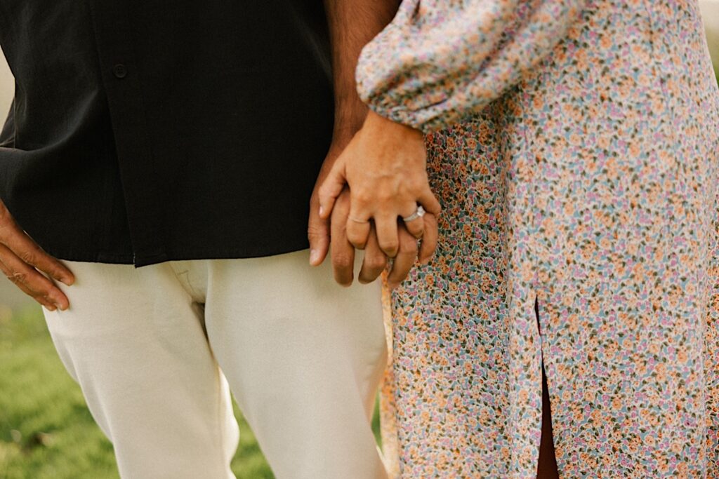 Close up photo of a man and woman holding hands during their family session
