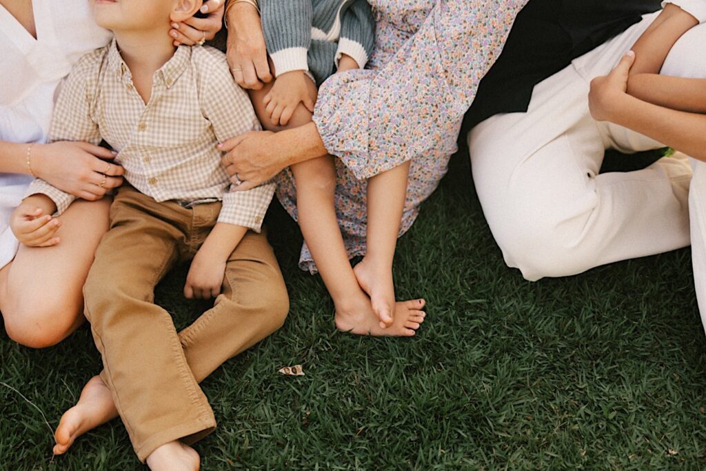 Close up photo of a family all sitting together in the grass