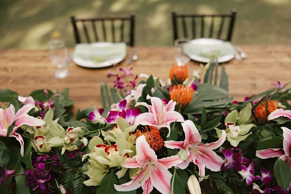 Pink, orange, and purple flowers on a wooden table as wedding decorations