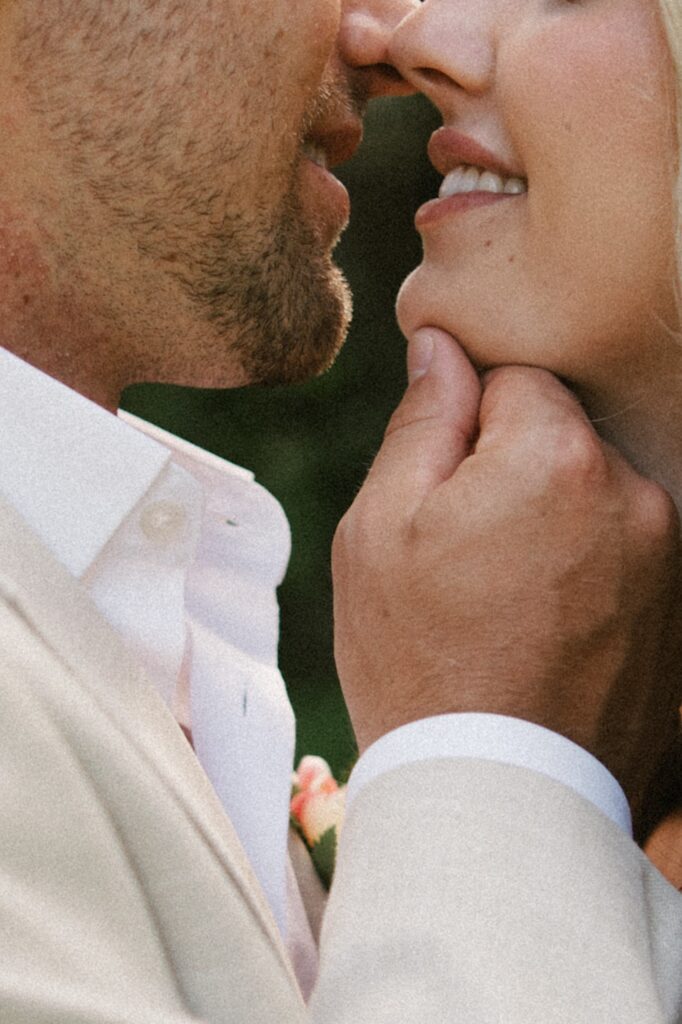 Close up photo of a man and woman about to kiss, the man's hand is underneath the woman's chin