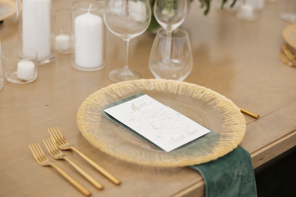 A menu sits on a plate resting on a table decorated for a wedding reception