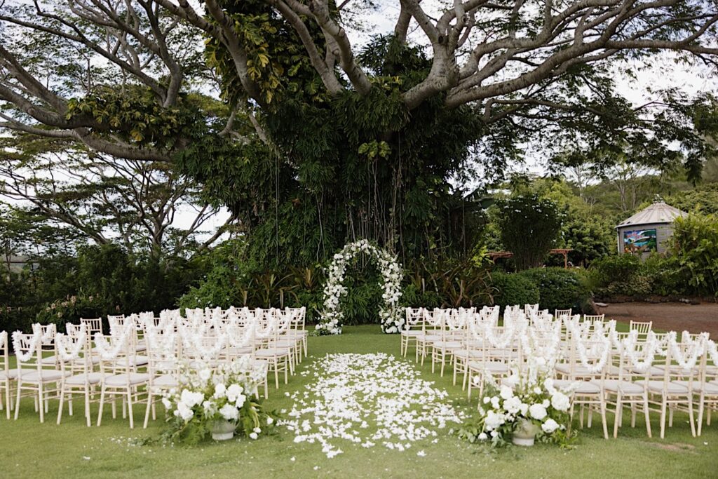 A wedding ceremony space at the farm of Kukui’ula decorated with white flowers