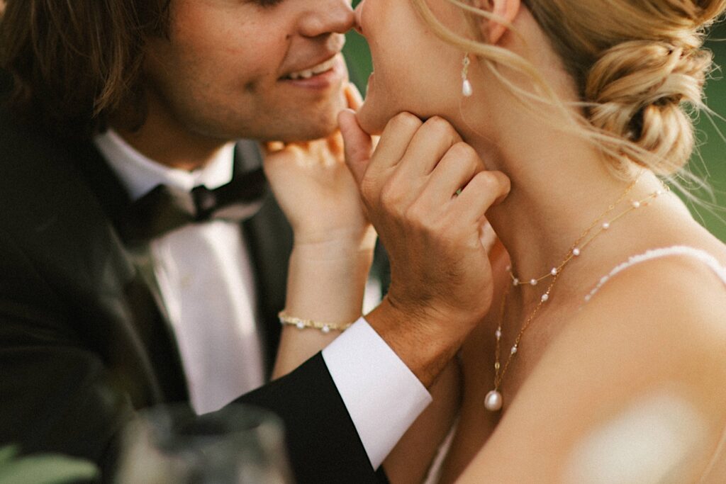 Close up photo of a bride and groom about to kiss one another on their wedding day
