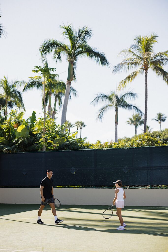 Jay and his daughter smile at one another while playing tennis together at the Four Seasons Resort on Maui