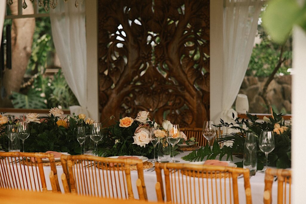 A table is decorated with pastel flowers for an intimate wedding reception at the venue, Male'ana Gardens on Oahu