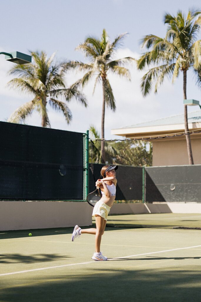 Jay and Mersadi's daughter swings her tennis racket while playing at the Four Seasons Resort on Maui