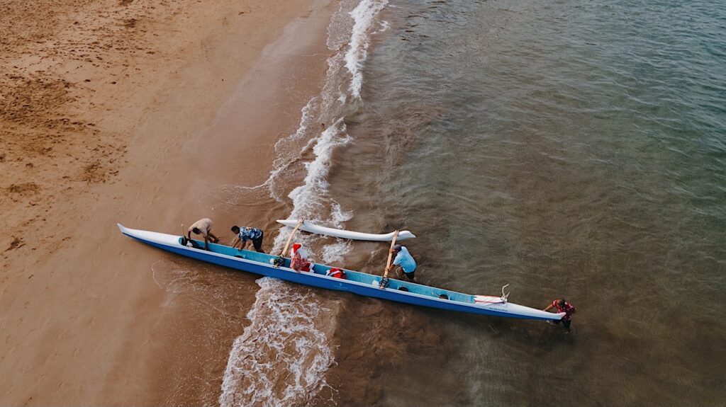 An aerial photo of a kayak coming ashore on the beach of the Four Seasons Resort on Maui at Wailea