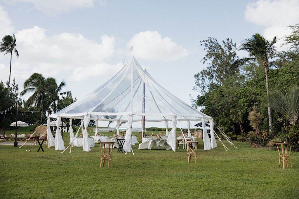 A clear tent set up for an outdoor wedding reception at a villa on Oahu