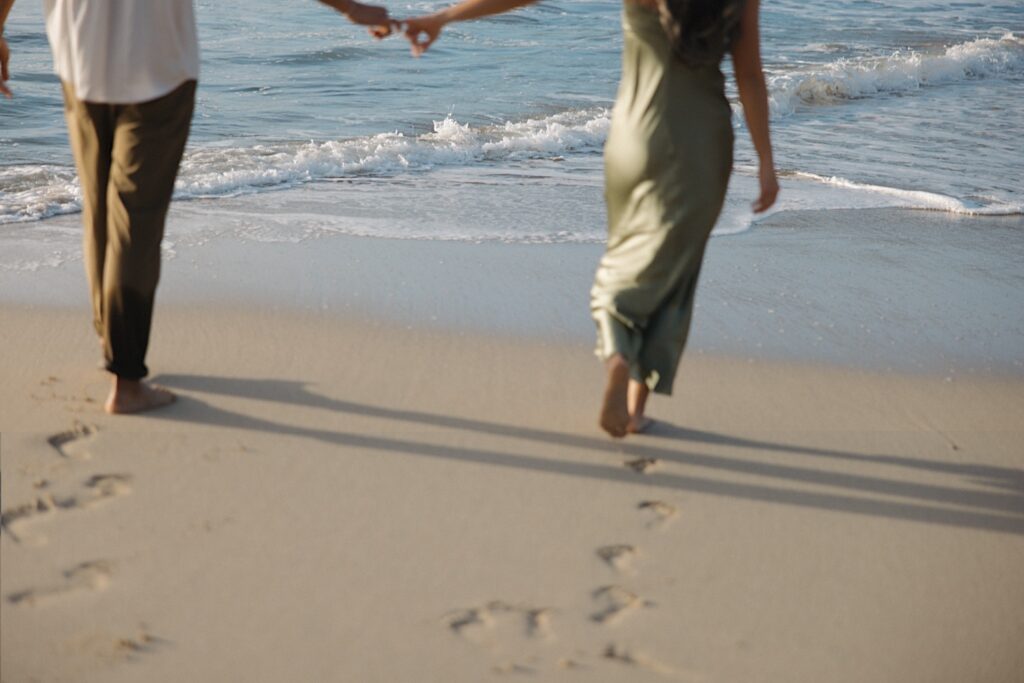 Hawaii Wedding photographer captures couples running away on the beach into the ocean at a beautiful resort in Hawaii for couples. 