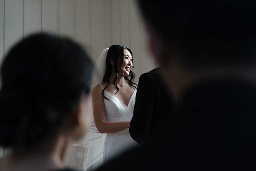 Bride smiles during intimate wedding ceremony in chapel at Four Seasons Oahu in Hawaii. 