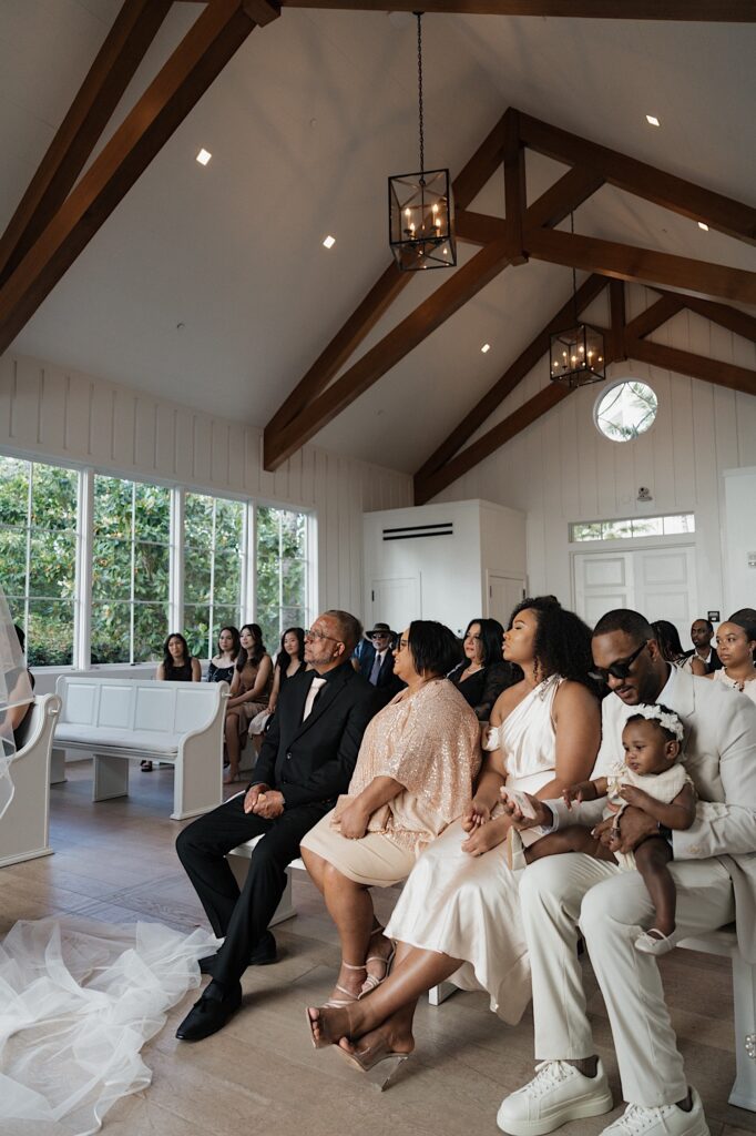 Guests watch as bride and groom get married in beautiful intimate chapel at Four Seasons Oahu in Hawaii. 