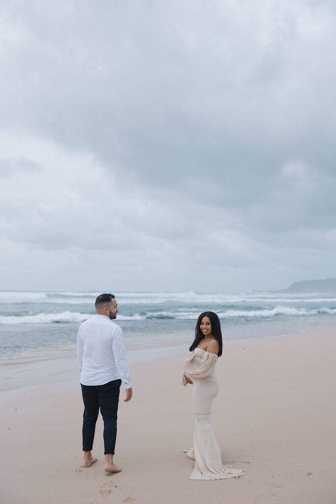 Couple celebrates pregnancy with couple portraits on the beach at Turtle Bay in Oahu, Hawaii. 